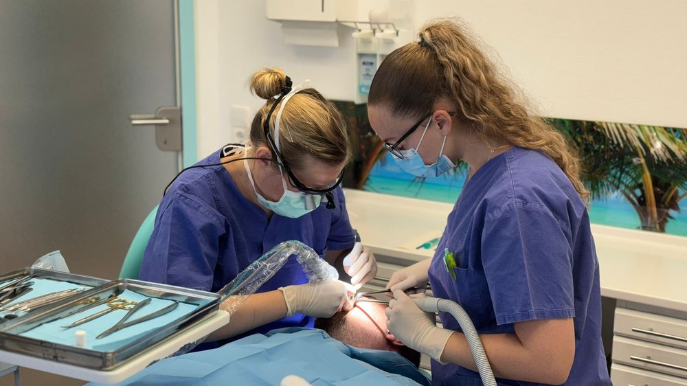 Zwei Behandlerinnen bei einem oralchirurgischen Eingriff